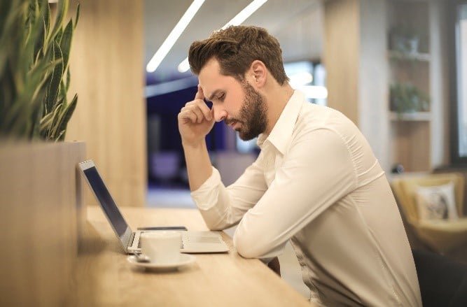 Egy férfi a laptopja előtt ül és dolgozik, ezzel is kékfény jut a szemébe